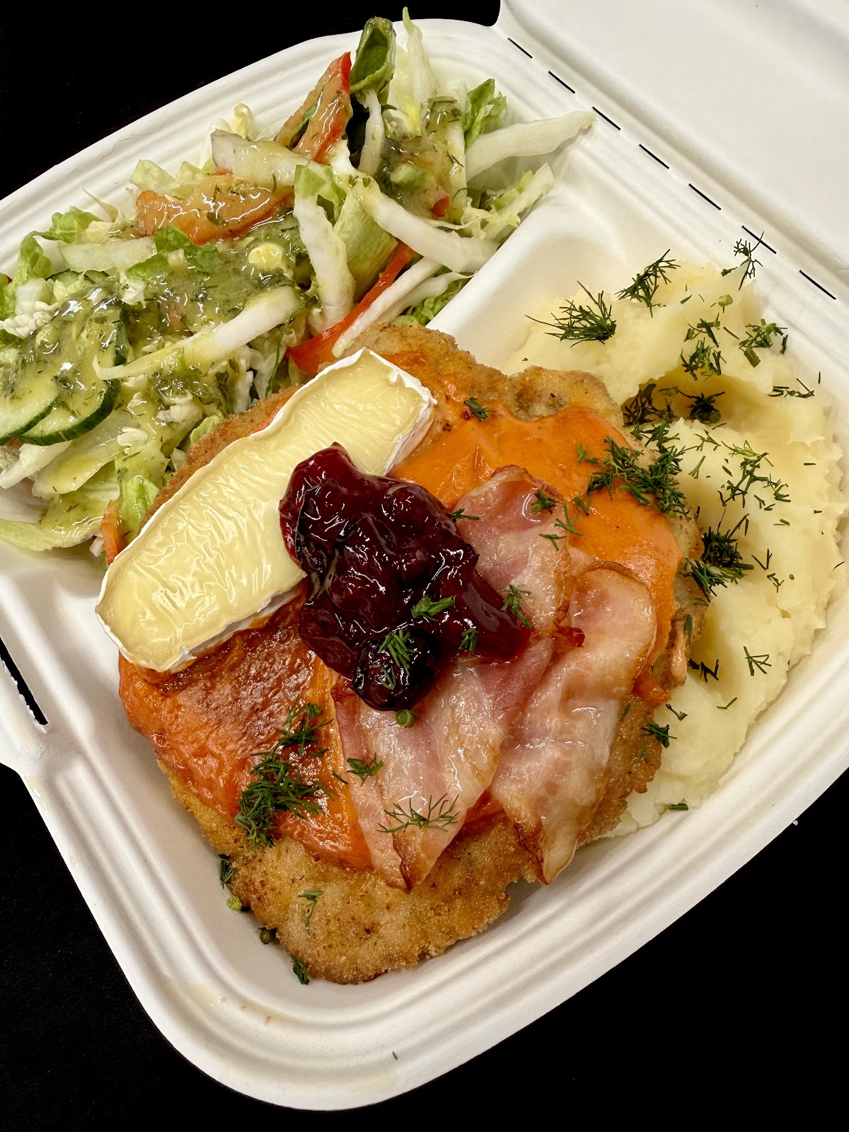 Kotlet zapiekany z serem, boczkiem i żurawiną, ziemniaki puree i surówka