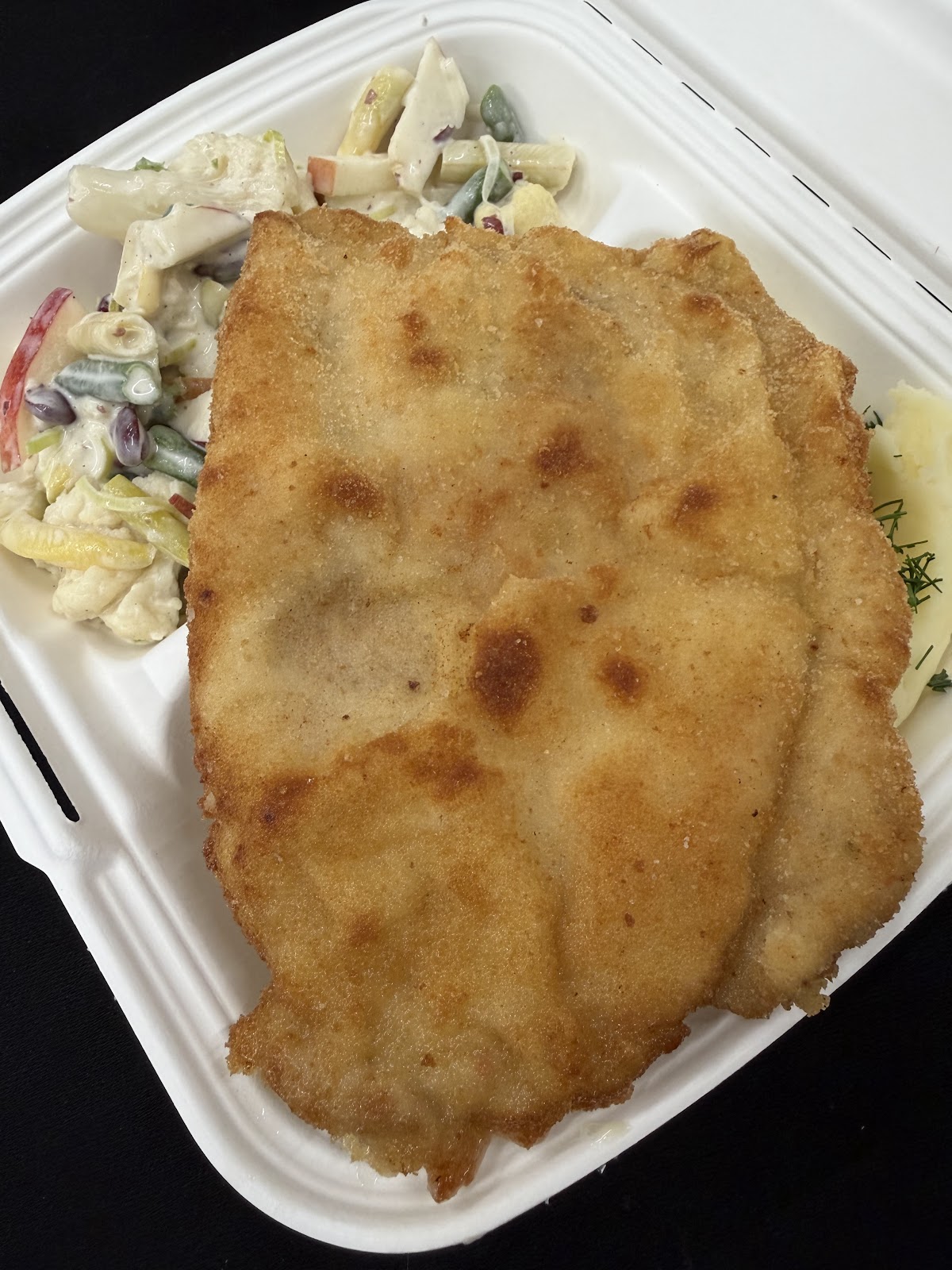 Kotlet schabowy w panierce z ziemniakami i surówką w pudełku na wynos